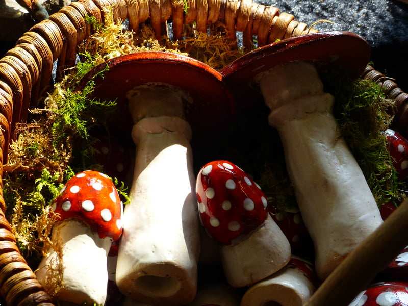 Keramikpilze mit rotem Hut in einem Korb voller Moos